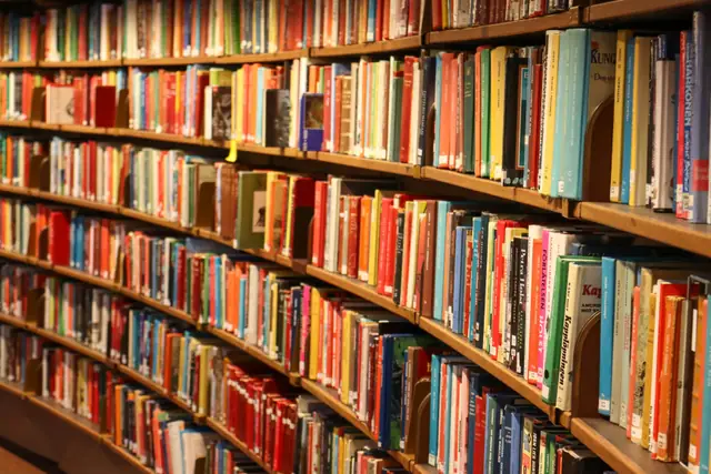 Curved wooden shelves packed with books in a reading room.